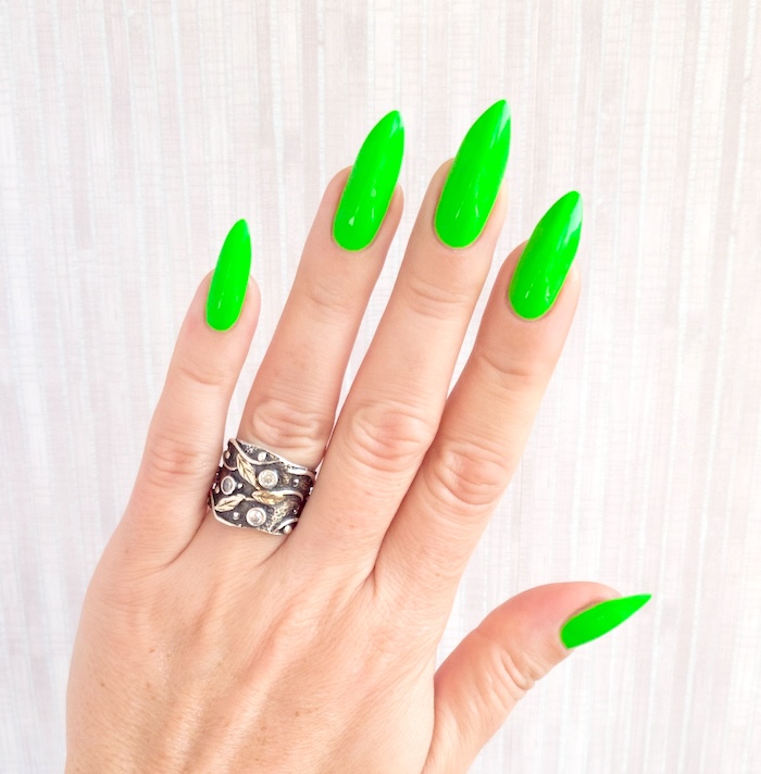 Bright green neon nails and silver ring.